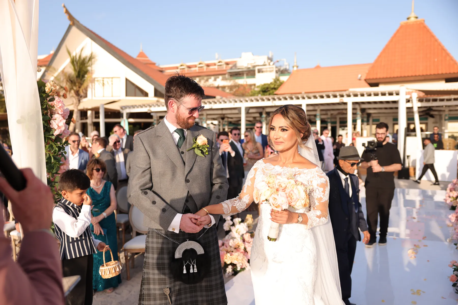 Bride and groom holding hands at their Dubai beach wedding ceremony