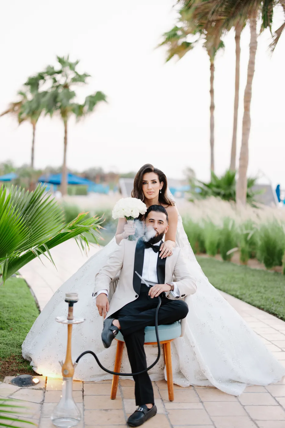 Newlyweds relaxing in the palm-lined gardens after their Dubai wedding ceremony