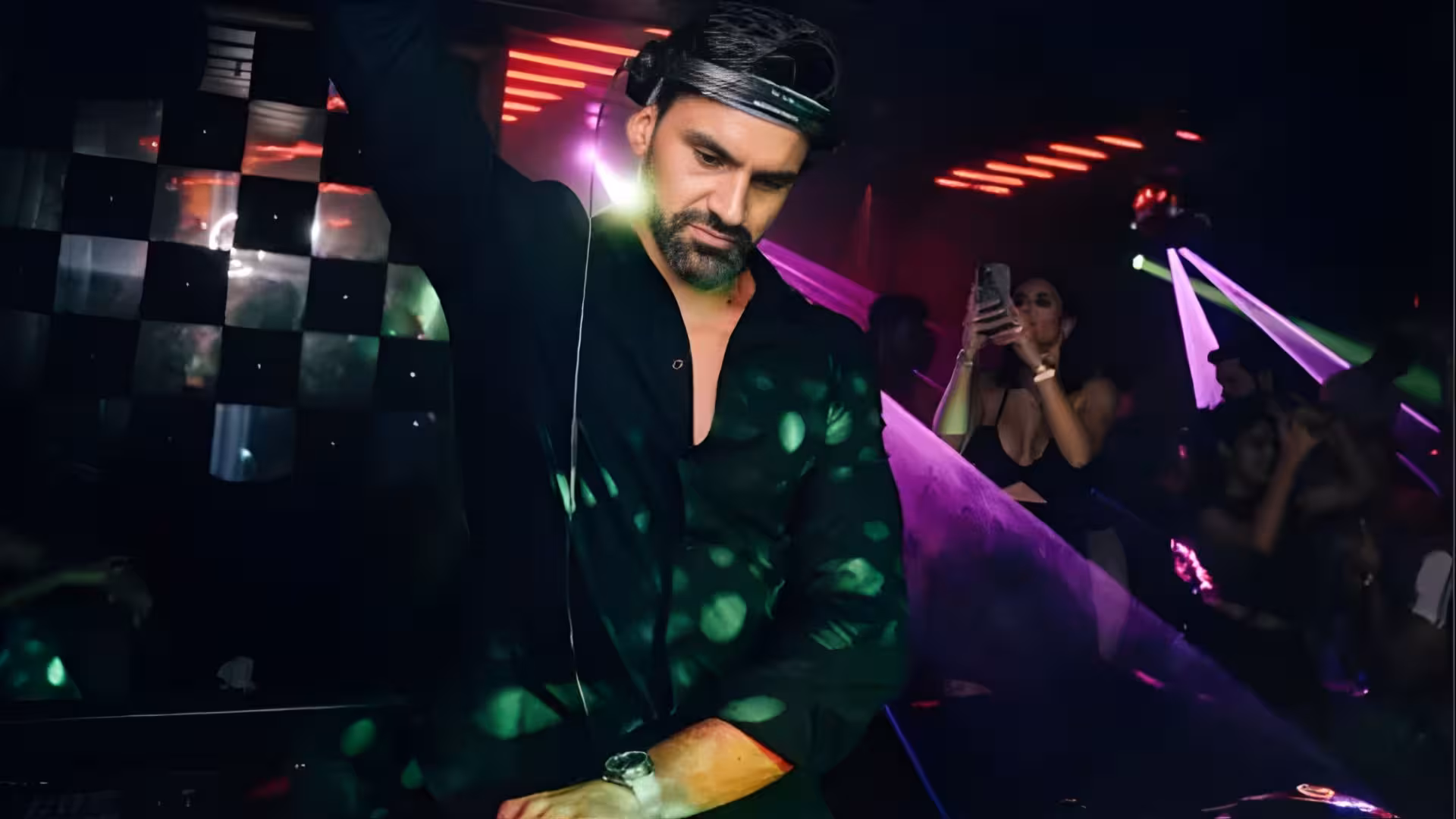 Darryl Rees professional DJ performing at a Dubai nightclub event with DJ equipment and lighting